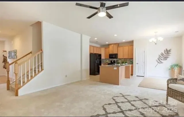 a living room with furniture kitchen view and a chandelier