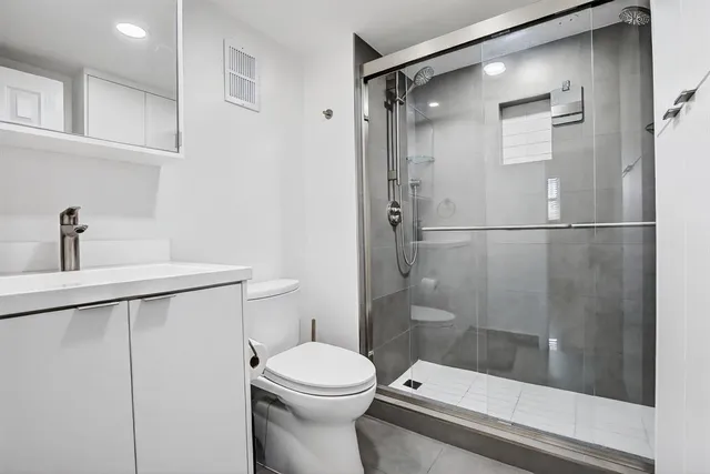 a bathroom with a shower toilet and sink