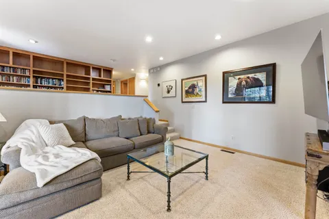 a living room with furniture and a wall painting