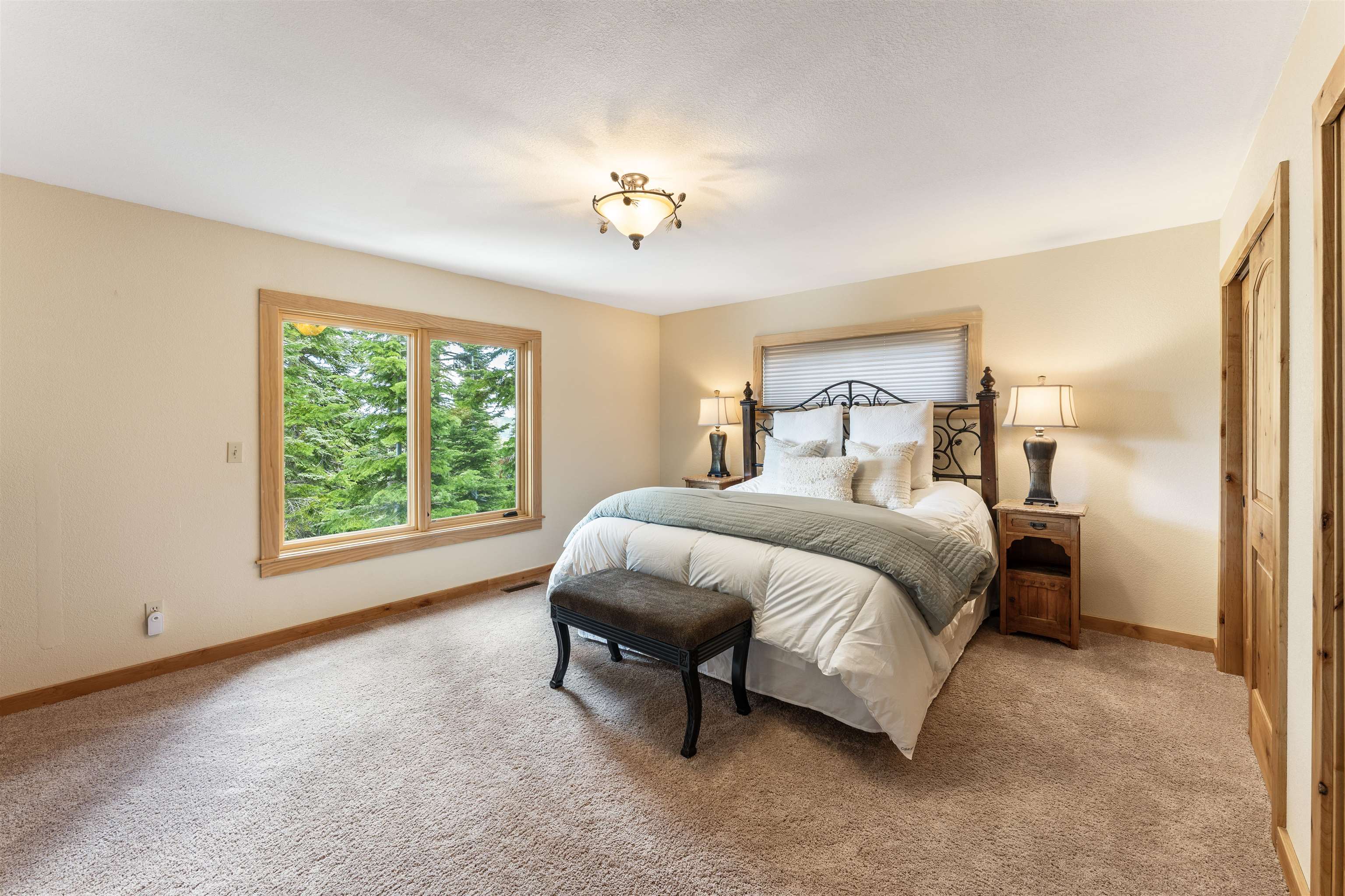 12185 Ski Slope Way Truckee, CA 96161 - Photo 8 of 27 a spacious bedroom with a bed and a chandelier