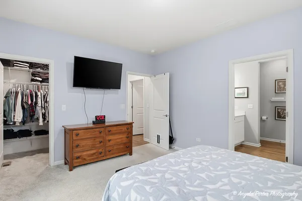 a spacious bedroom with a bed and a flat screen tv