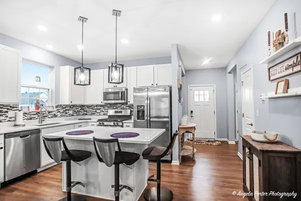 a kitchen with a table chairs refrigerator and cabinets
