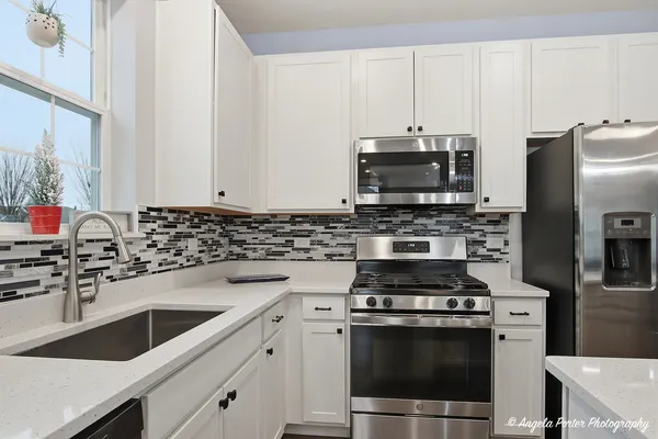 a kitchen with stainless steel appliances a stove a sink and a microwave