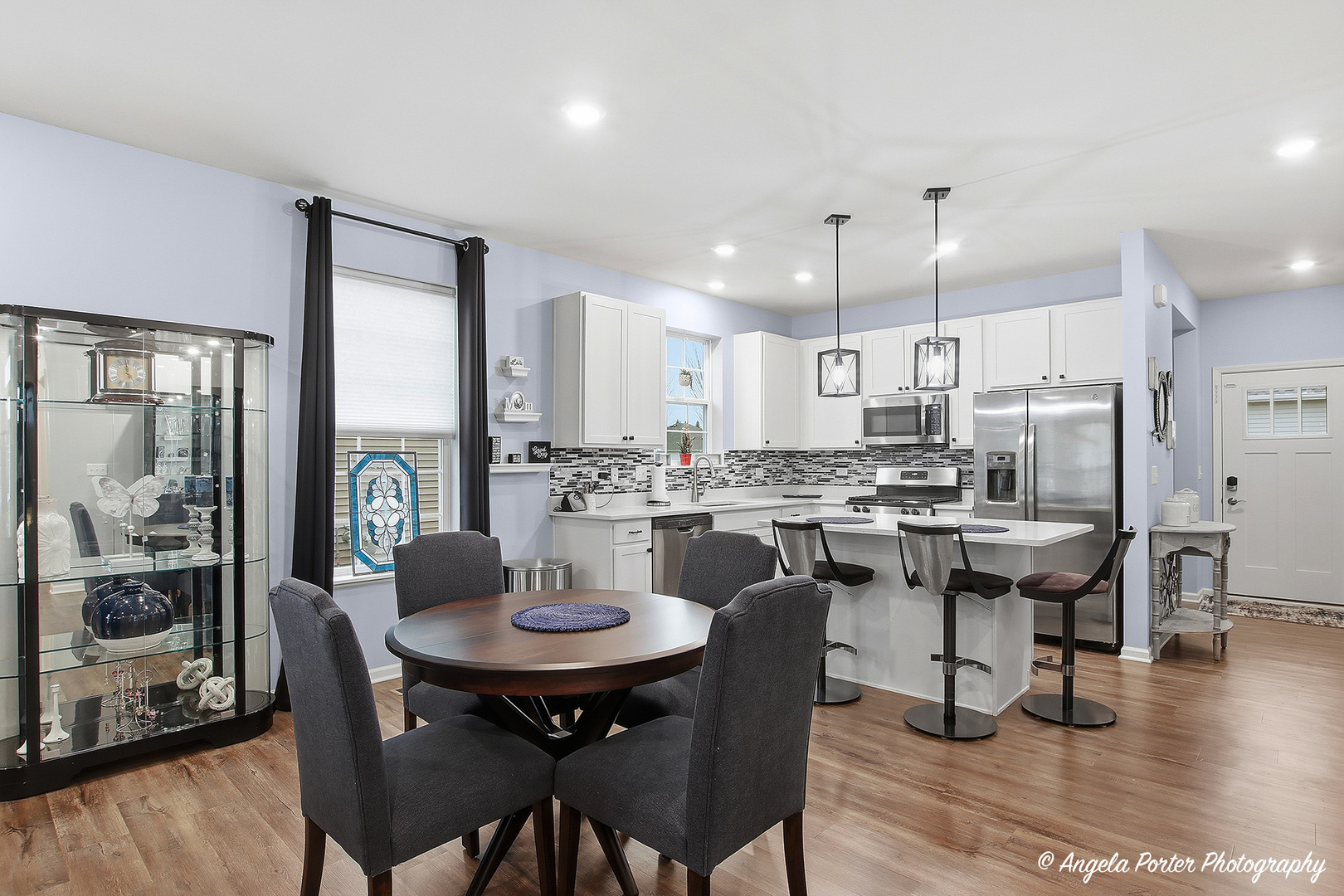 9186 Ritz Court Huntley, IL 60142 - Photo 10 of 36 a kitchen with a dining table chairs and refrigerator