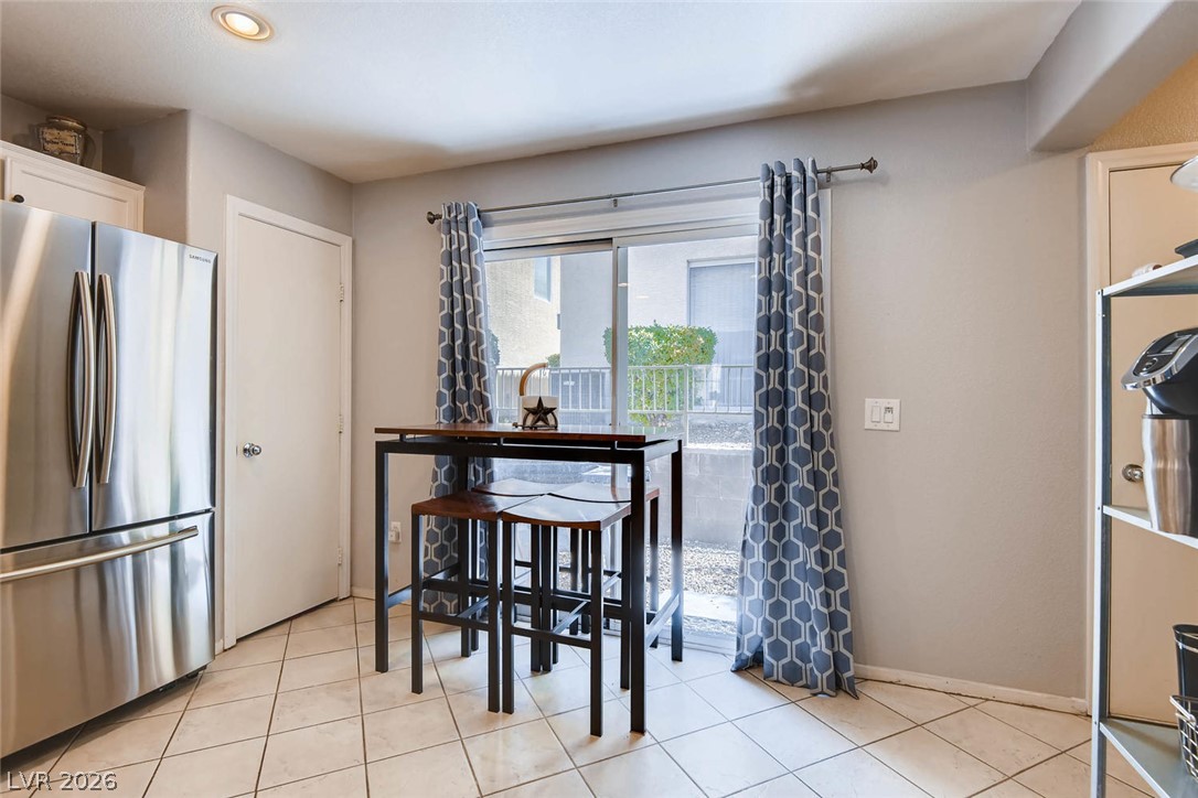 10451 Processor Court Las Vegas, NV 89129 - Photo 13 of 28 A well-lit kitchen with tiled floors and convenient patio access.