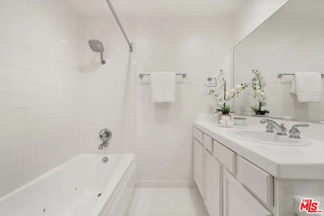 a bathroom with a tub sink and mirror