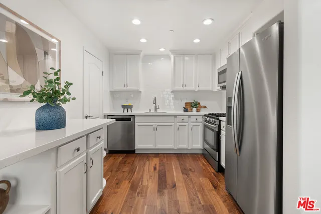 a kitchen with white cabinets and stainless steel appliances