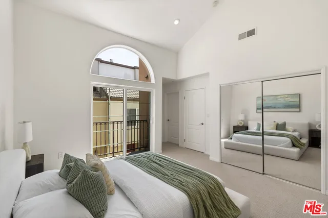 a spacious bedroom with a bed and a large window