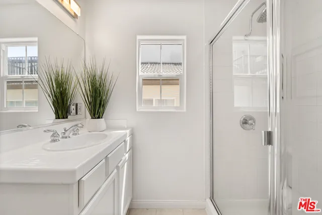 a bathroom with a sink a mirror and a shower