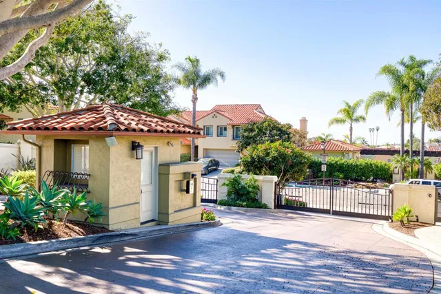 a view of a white house with a small yard and plants