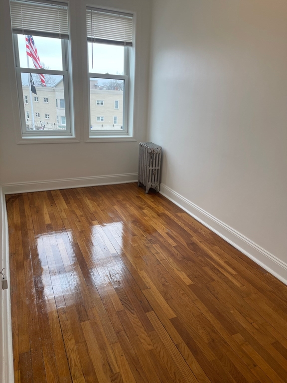 10 Yeamans Street, Unit 17A Revere, MA 02151 - Photo 4 of 6 an empty room with wooden floor and windows