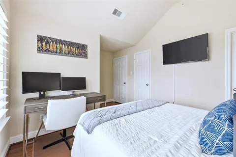 a bedroom with a bed and a flat screen tv