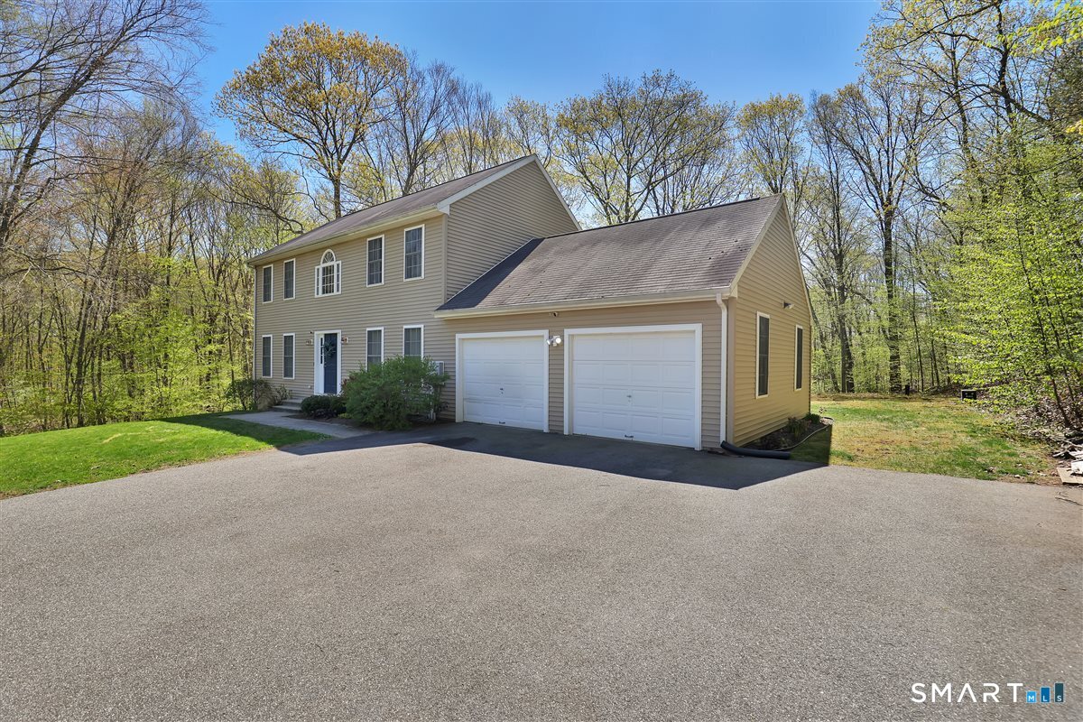 345 Hebron Road Andover, CT 06232 - Photo 2 of 39 a front view of a house with a yard and garage