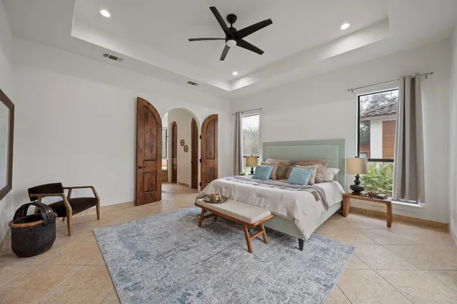 a spacious bedroom with a bed and a chandelier