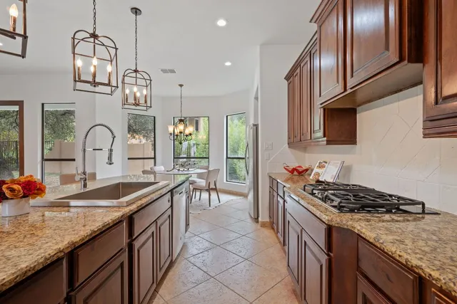 a kitchen with granite countertop a sink stove and cabinets