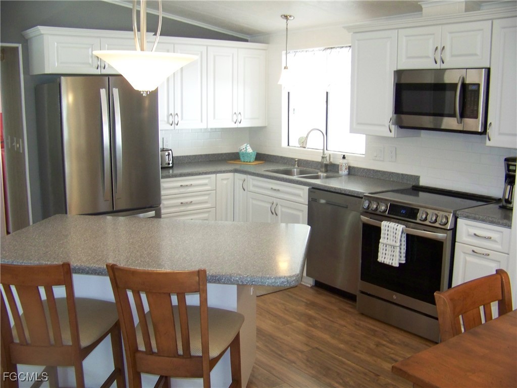 15550 Burnt Store Road, Unit 62 Punta Gorda, FL 33955 - Photo 20 of 50 a kitchen with stainless steel appliances granite countertop a stove a sink dishwasher a microwave oven with granite countertops and cabinets