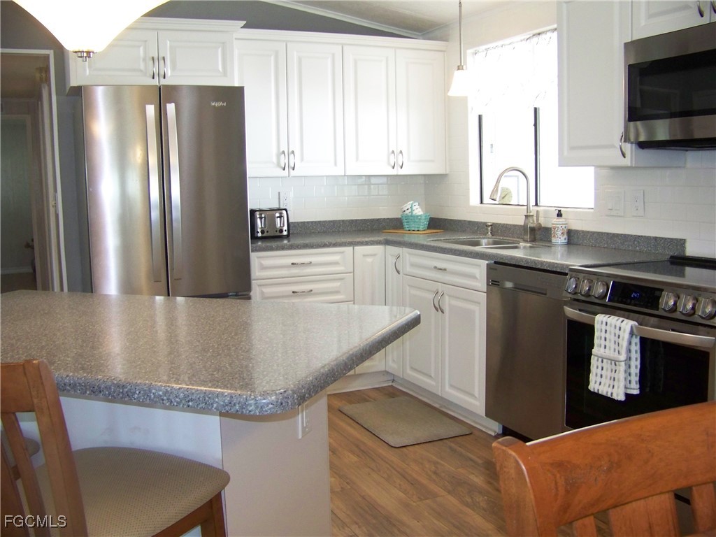 15550 Burnt Store Road, Unit 62 Punta Gorda, FL 33955 - Photo 23 of 50 a kitchen with stainless steel appliances granite countertop a sink stove and refrigerator