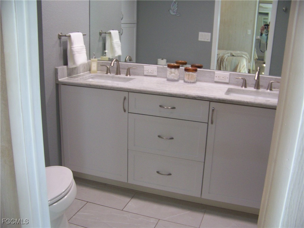 15550 Burnt Store Road, Unit 62 Punta Gorda, FL 33955 - Photo 32 of 50 a bathroom with a granite countertop sink and a mirror