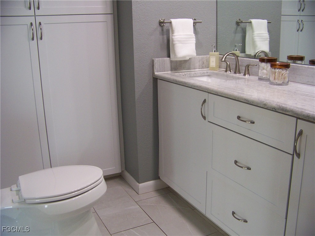 15550 Burnt Store Road, Unit 62 Punta Gorda, FL 33955 - Photo 33 of 50 a bathroom with a granite countertop sink a toilet a mirror and shower