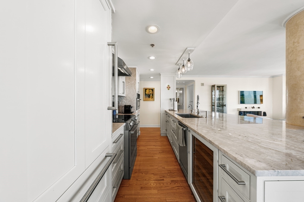 8 Museum Way, Unit 2304 Cambridge, MA 02141 - Photo 16 of 39 a hallway with kitchen island granite countertop a stove and a sink