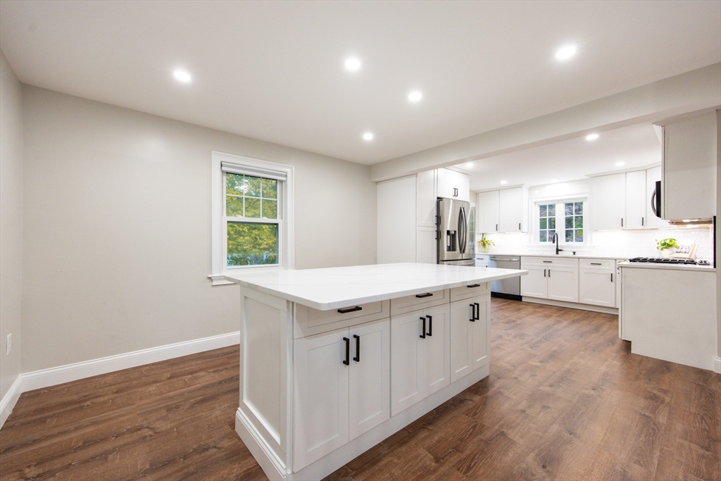 841 Lincoln Street Franklin, MA 02038 - Photo 4 of 25 a large white kitchen with stainless steel appliances granite countertop a large counter top and a wooden floors