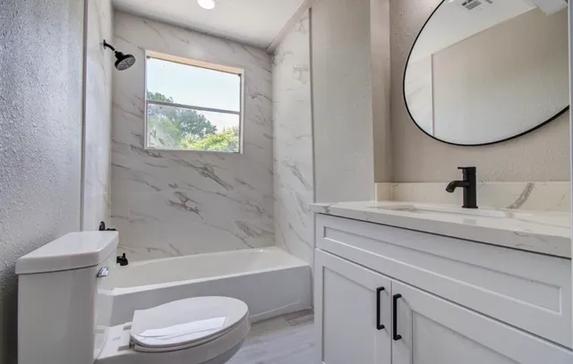 a bathroom with a toilet a sink and a bathtub