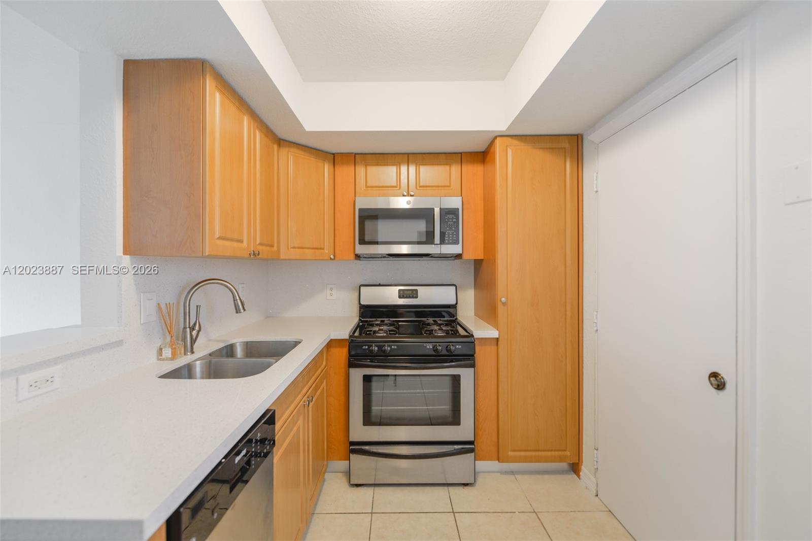 7737 Southwest 88th Street, Unit C312 Miami, FL 33156 - Photo 10 of 32 a kitchen with a sink a stove and cabinets