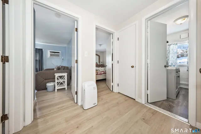a view of a hallway with wooden floor and a living room
