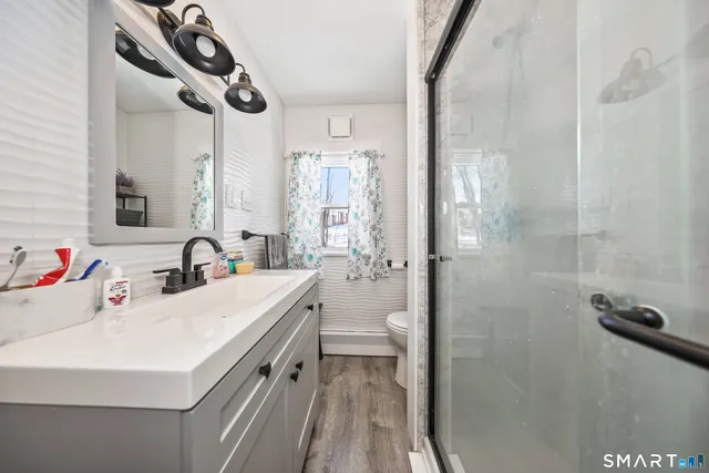 a bathroom with a sink a toilet and shower