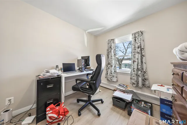 a view of a workspace with furniture and a window