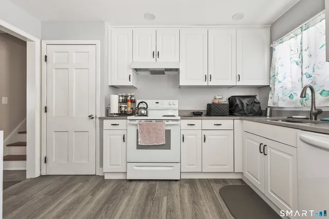 a kitchen with white cabinets and white appliances