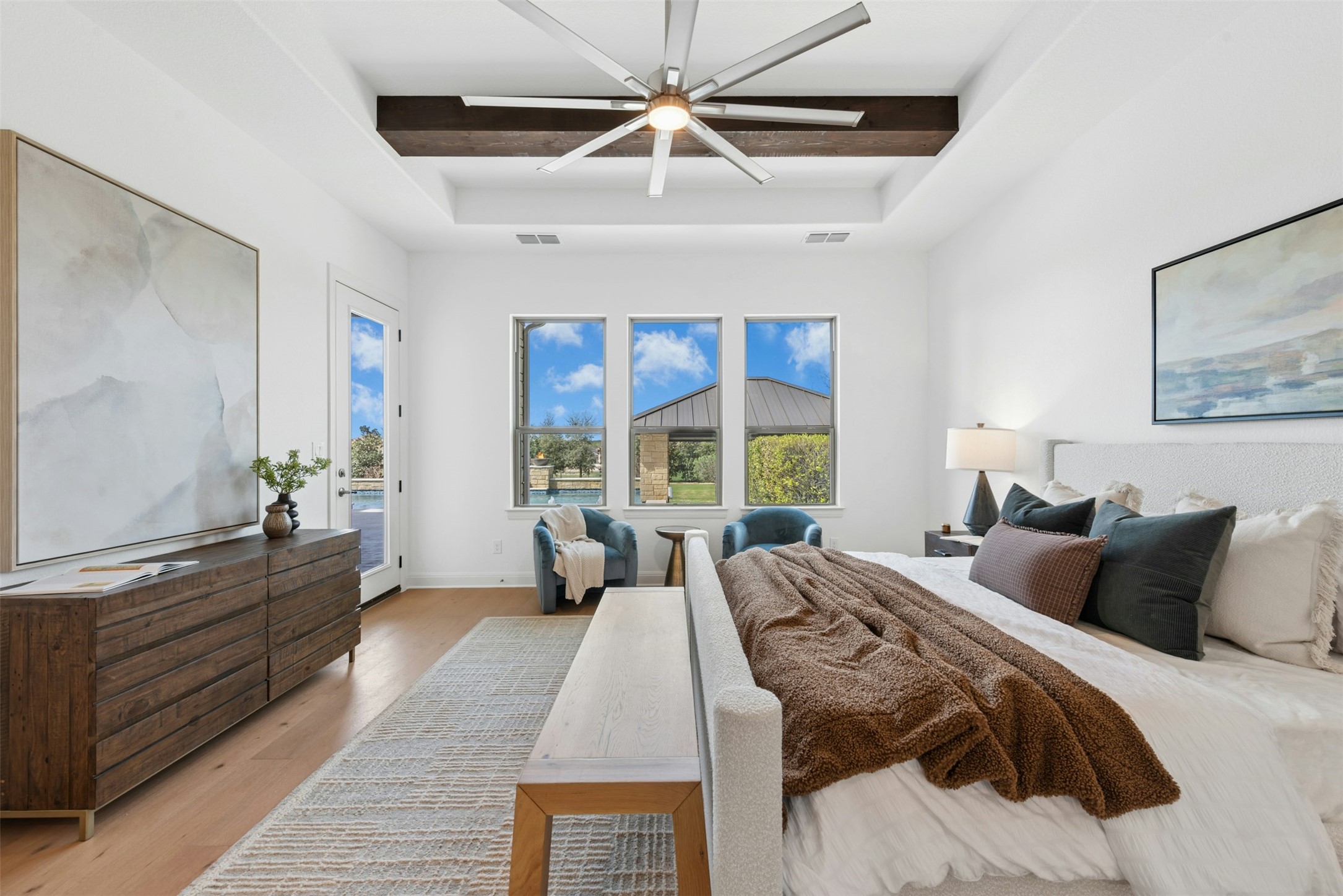 401 Brave Face Street Leander, TX 78641 - Photo 14 of 35 Bedroom featuring a tray ceiling, light wood-style floors, ceiling fan, access to exterior, and beamed ceiling