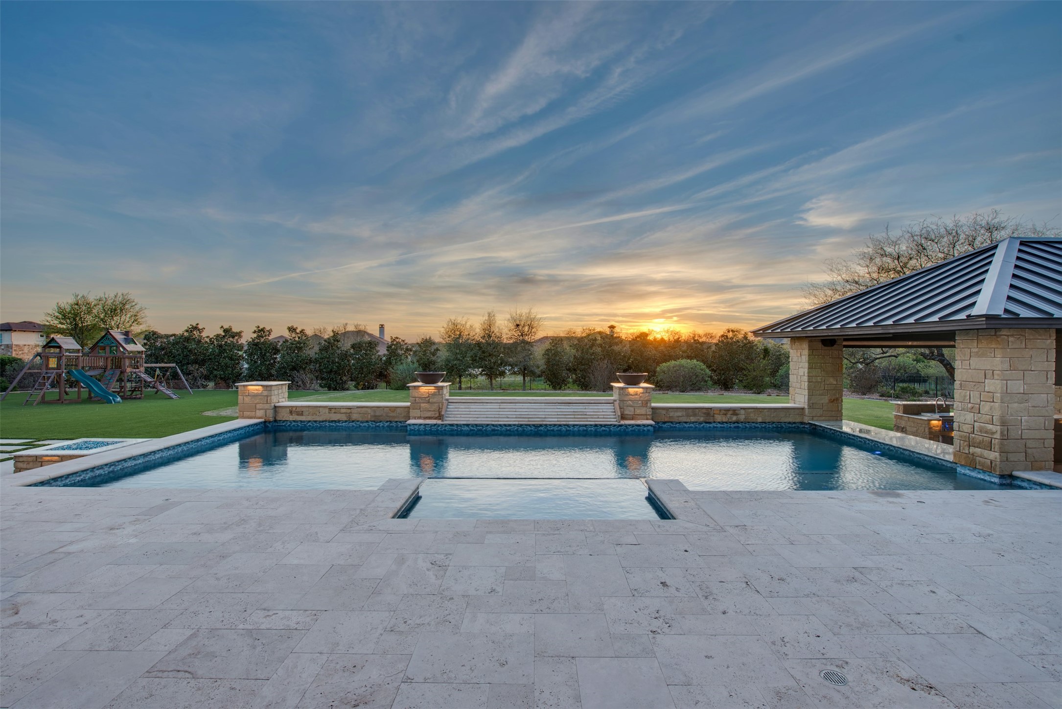 401 Brave Face Street Leander, TX 78641 - Photo 2 of 35 Pool at dusk featuring a playground, an outdoor pool, and a patio