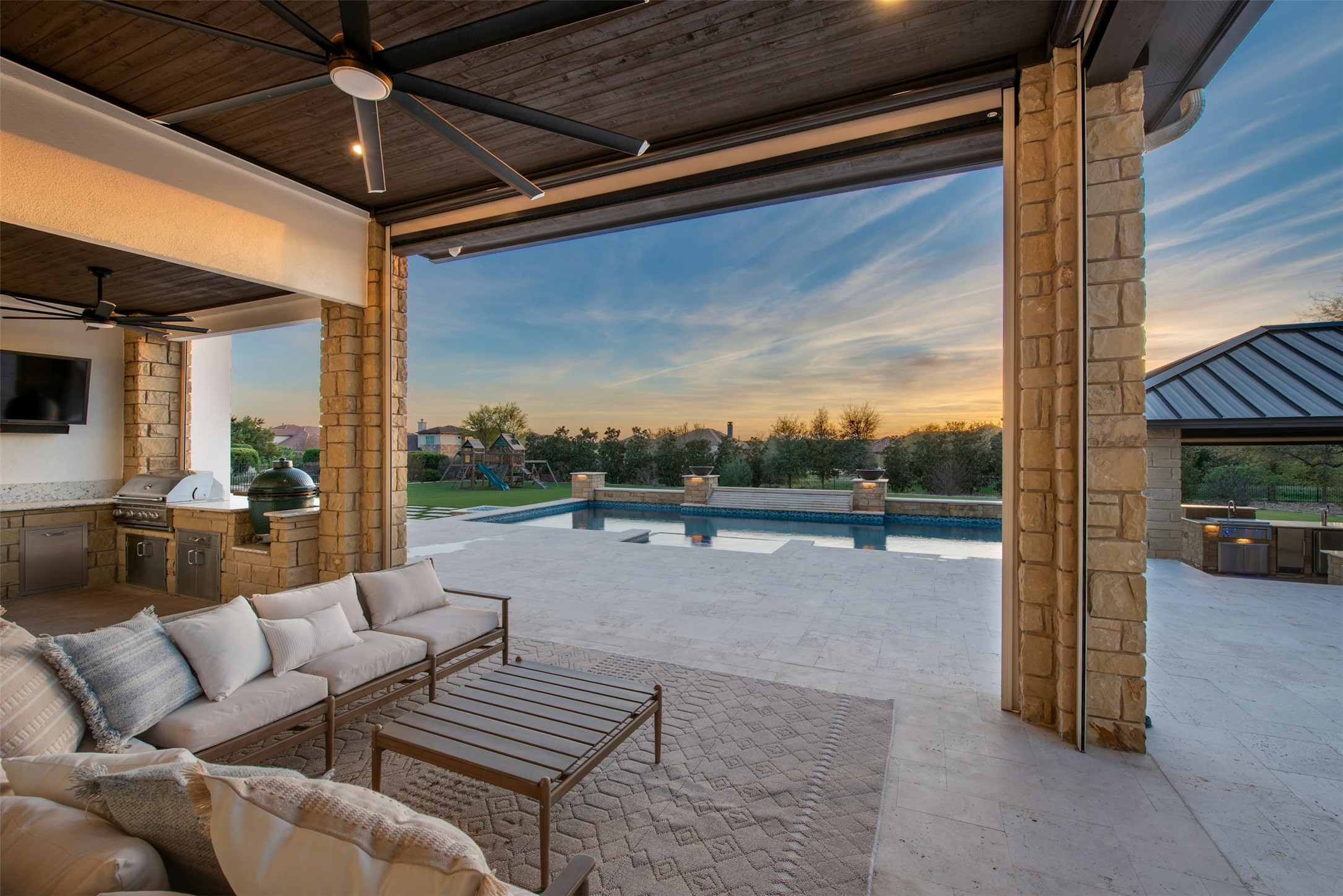 401 Brave Face Street Leander, TX 78641 - Photo 22 of 35 Patio terrace at dusk with an outdoor kitchen with living area, ceiling fan, an outdoor pool, and a patio