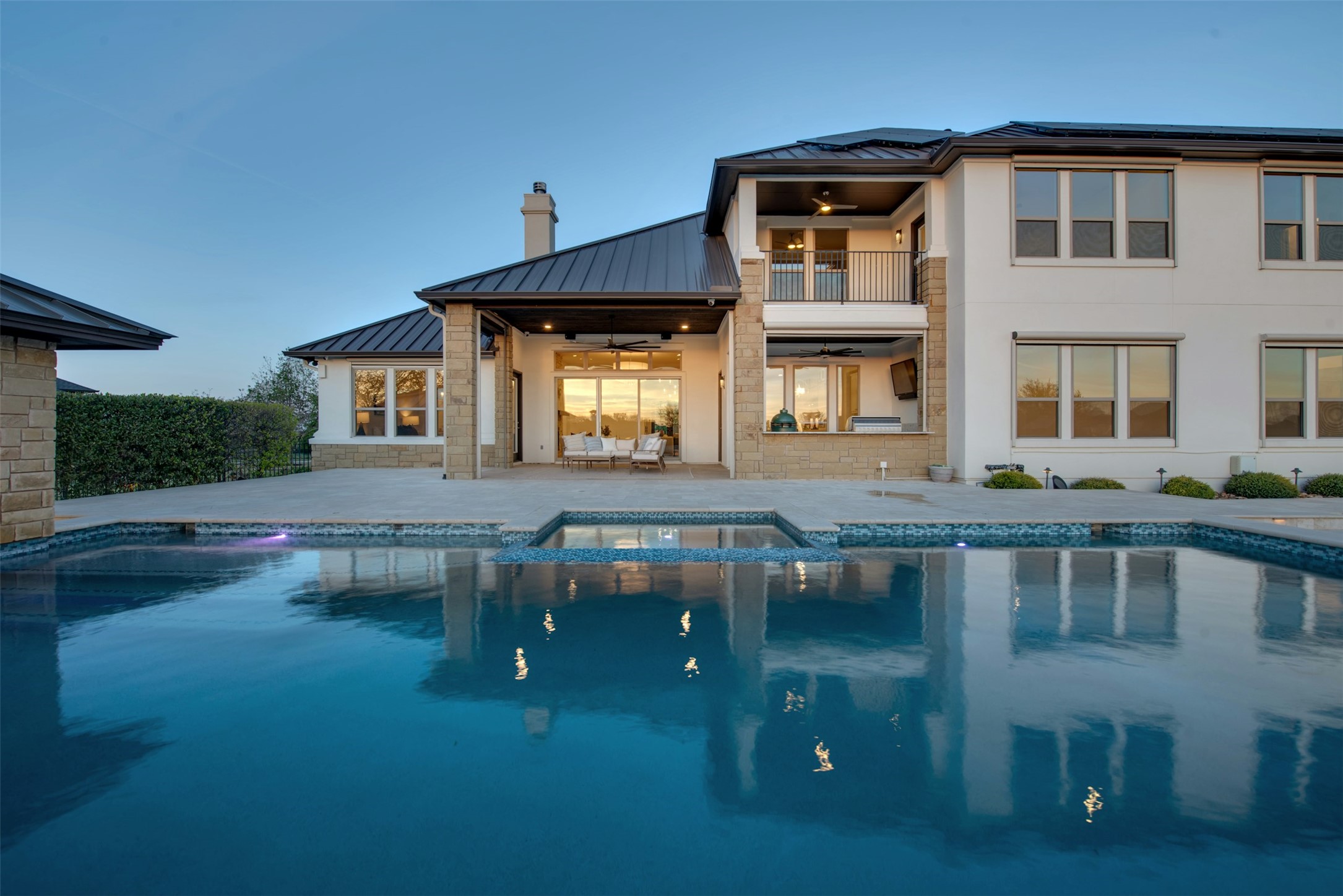 401 Brave Face Street Leander, TX 78641 - Photo 26 of 35 Back of property featuring a balcony, a pool with connected hot tub, and a chimney