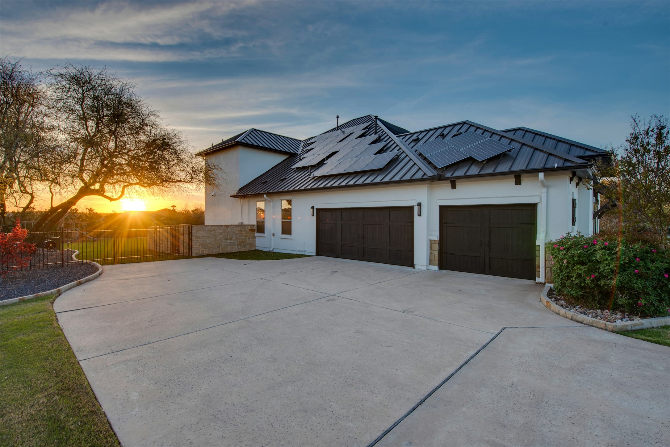 401 Brave Face Street Leander, TX 78641 - Photo 32 of 35 View of front of property featuring side loaded garage roof mounted solar panels, a garage, driveway, stucco siding, and a standing seam roof