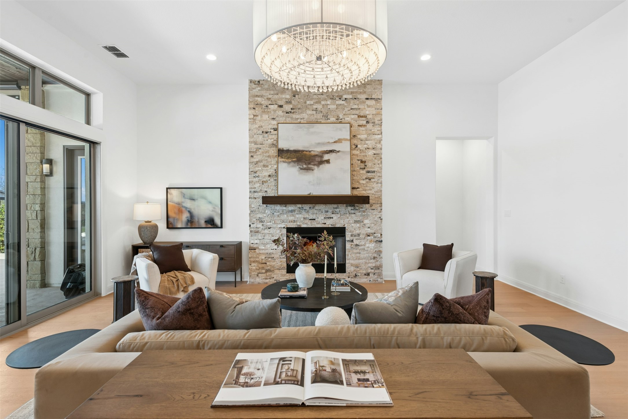 401 Brave Face Street Leander, TX 78641 - Photo 7 of 35 Living room featuring light wood-type flooring, a fireplace, and hanging lights