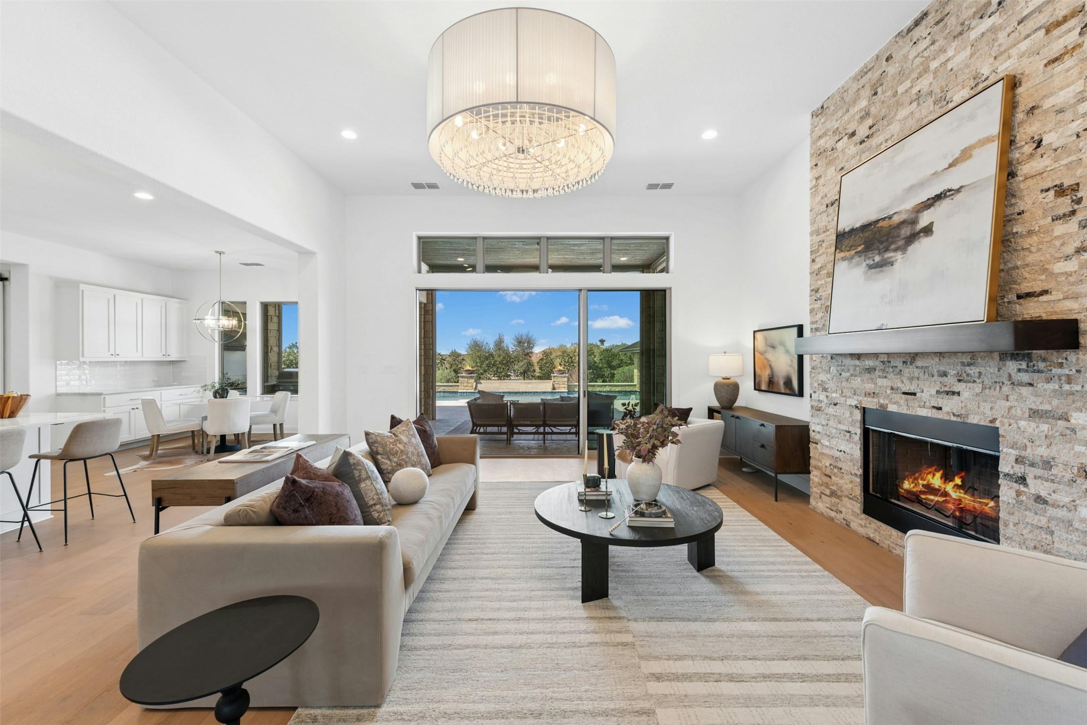 401 Brave Face Street Leander, TX 78641 - Photo 8 of 35 Living room with hanging lights, light wood finished floors, and a fireplace