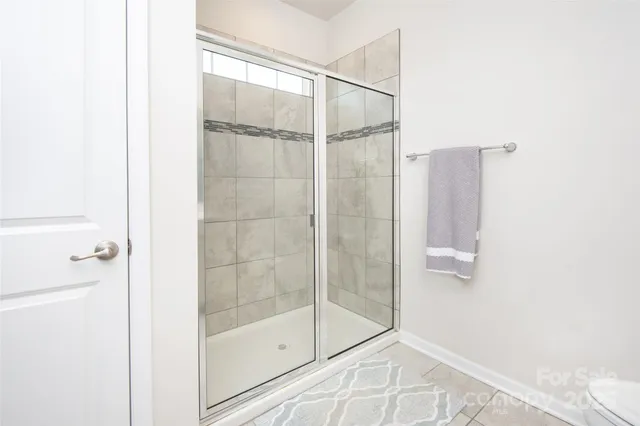 a bathroom with a shower and a glass door