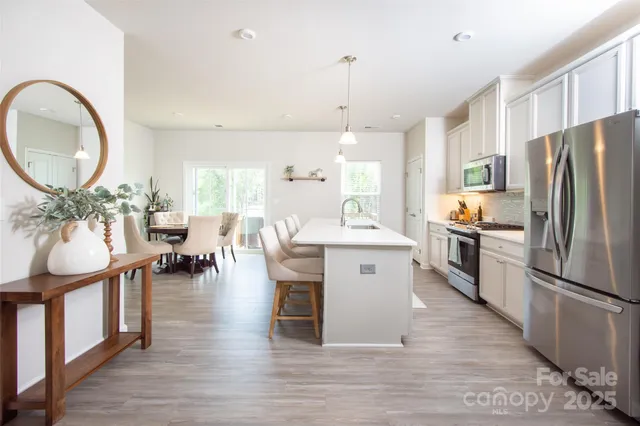 a very nice looking kitchen with granite countertop a large counter top space a sink stainless steel appliances and cabinets