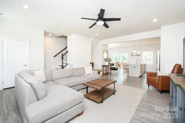 a living room with furniture and a view of kitchen