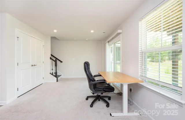 a view of a workspace with furniture and a window