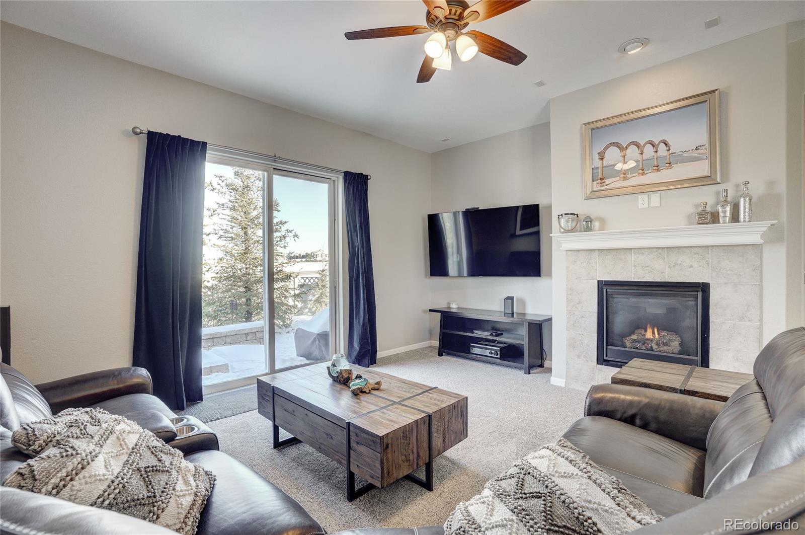 3563 Vestal Loop Broomfield, CO 80023 - Photo 14 of 38 a living room with furniture a flat screen tv and a fireplace