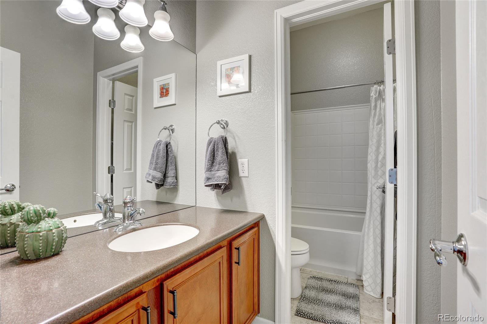 3563 Vestal Loop Broomfield, CO 80023 - Photo 21 of 38 a bathroom with a granite countertop sink toilet and shower