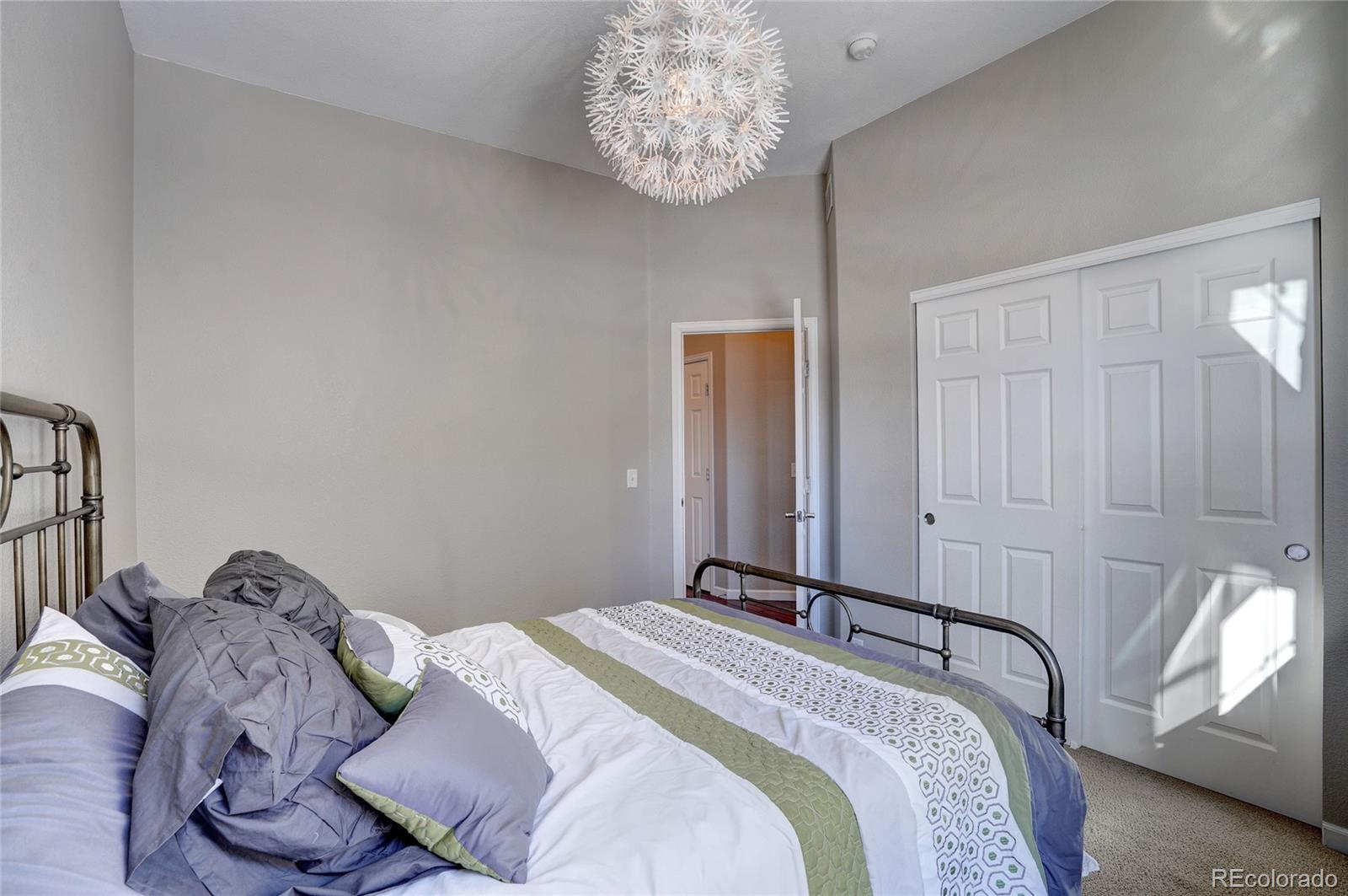 3563 Vestal Loop Broomfield, CO 80023 - Photo 24 of 38 a bedroom with a bed and a chandelier