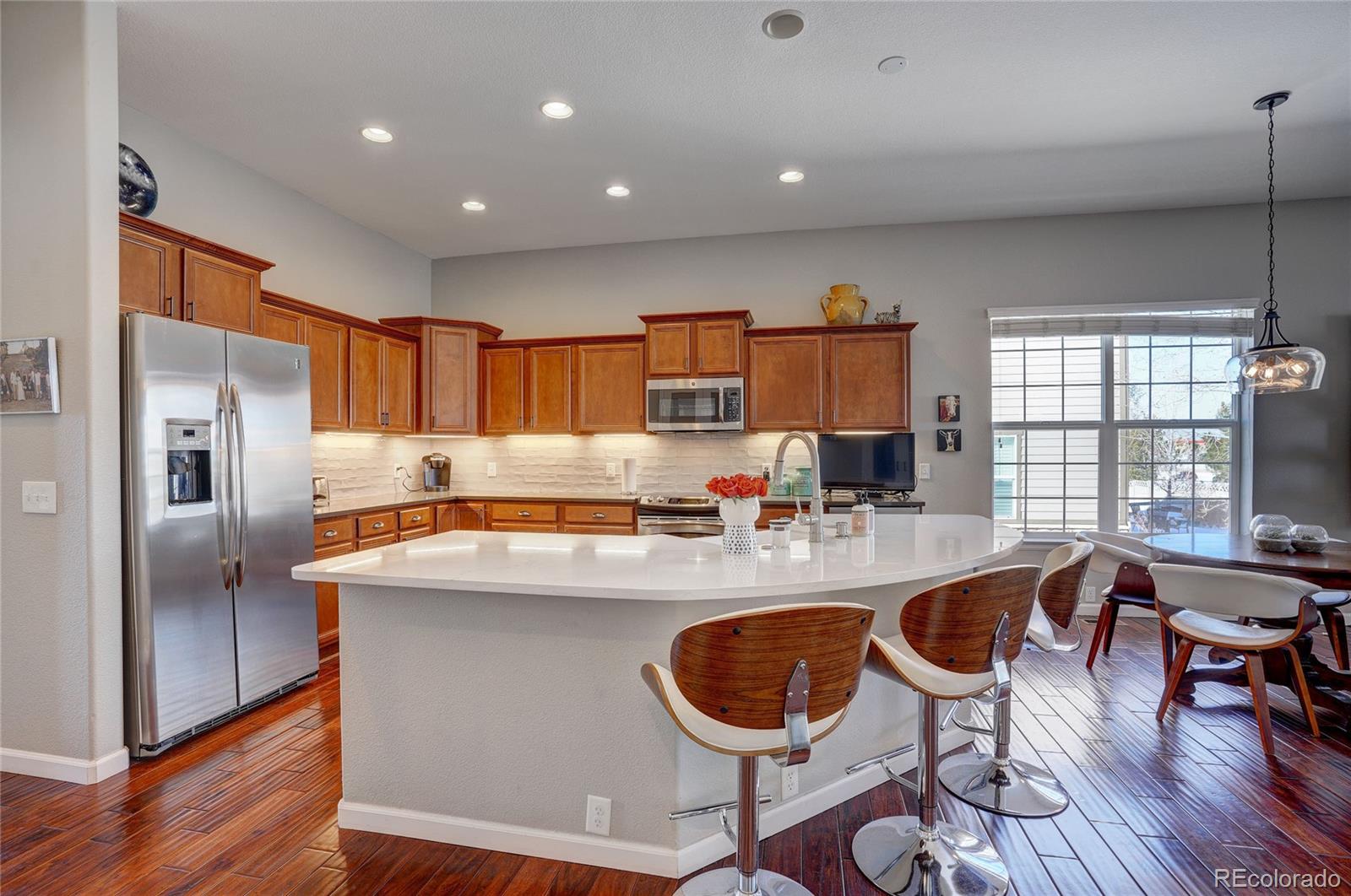 3563 Vestal Loop Broomfield, CO 80023 - Photo 8 of 38 a kitchen with sink a refrigerator and chairs