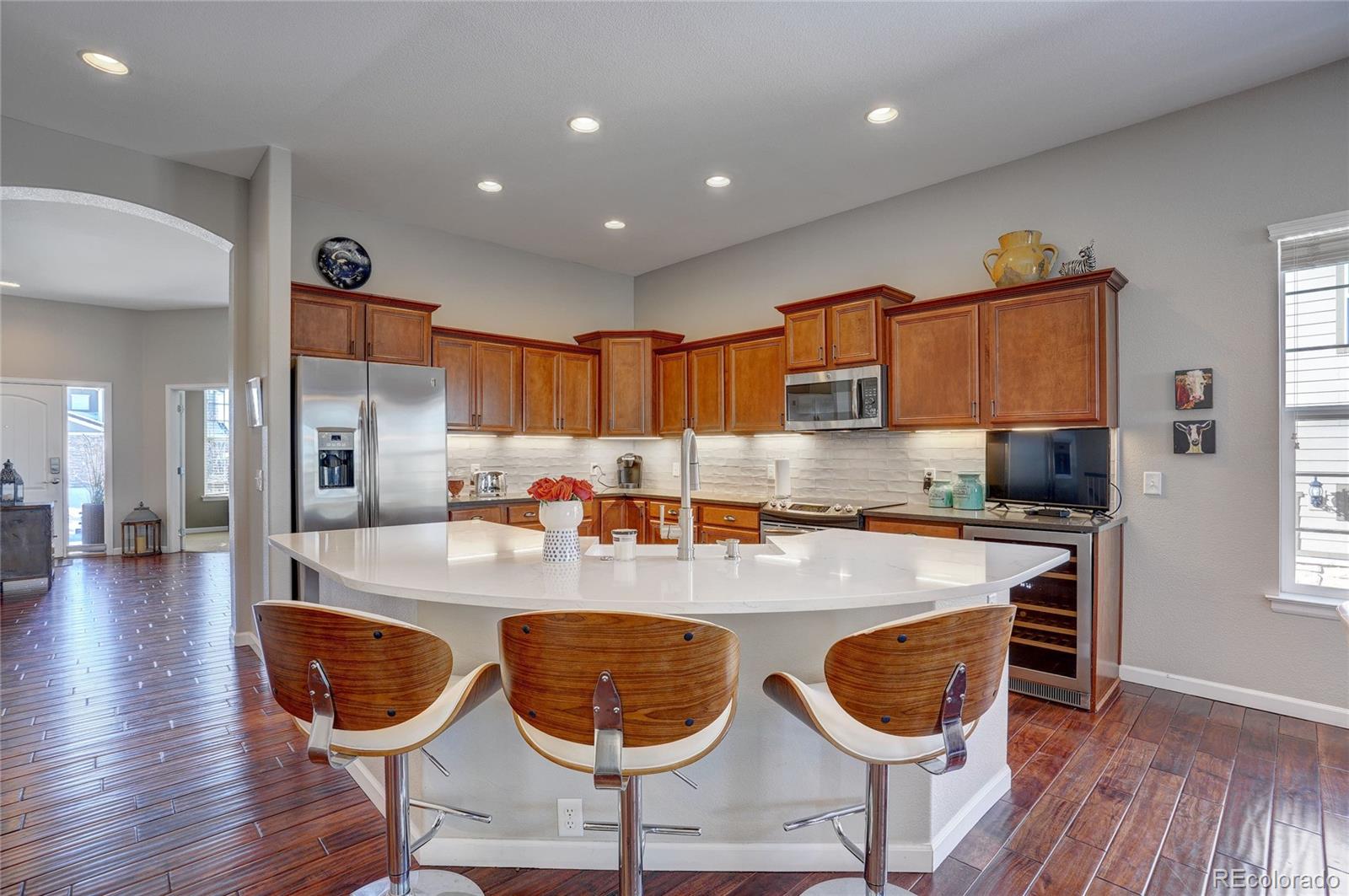 3563 Vestal Loop Broomfield, CO 80023 - Photo 9 of 38 a kitchen with stainless steel appliances granite countertop a stove a sink a dining table and chairs with wooden floor