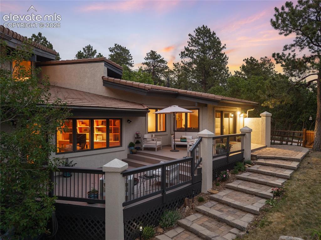 12730 Bridle Bit Road Colorado Springs, CO 80908 - Photo 44 of 50 Multi-level rear exterior featuring a composite deck, stucco siding, and a tile roof