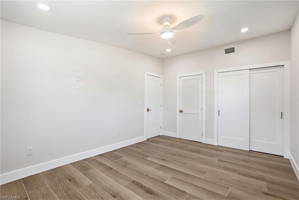 8336 Lagoon Road Fort Myers Beach, FL 33931 - Photo 14 of 50 This room features wood-look tile flooring, bright white walls, and recessed lighting - Virtually Edited Image
