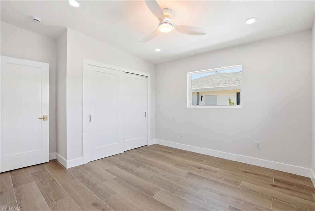 8336 Lagoon Road Fort Myers Beach, FL 33931 - Photo 26 of 50 The room features light-toned wood-look flooring, a modern ceiling fan with lighting, and recessed lighting - Virtually Edited Image